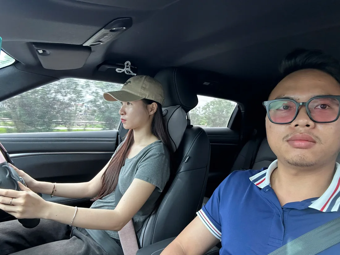 Thầy ngồi cạnh hướng dẫn học viên nữ lái xe